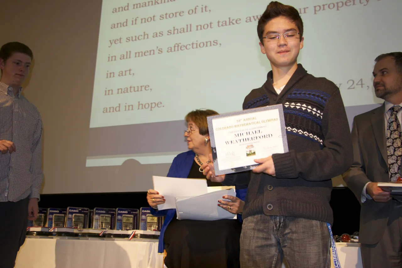 A contestant posing with their certificate.