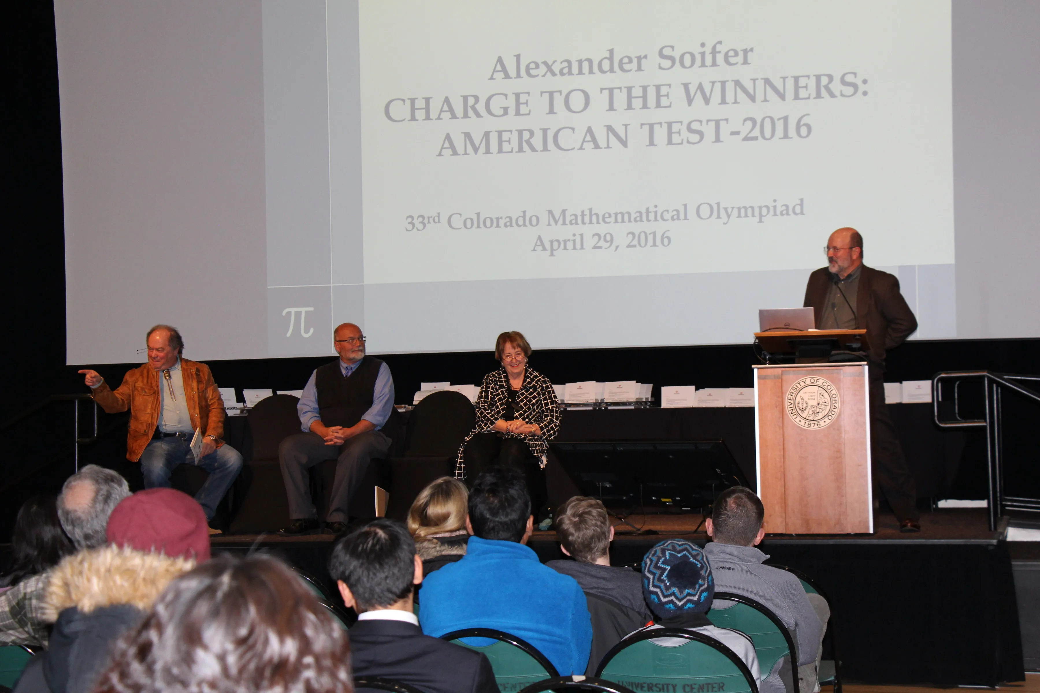 Speaker delivering a presentation with a slide saying "Charge to the Winners: American Test 2016