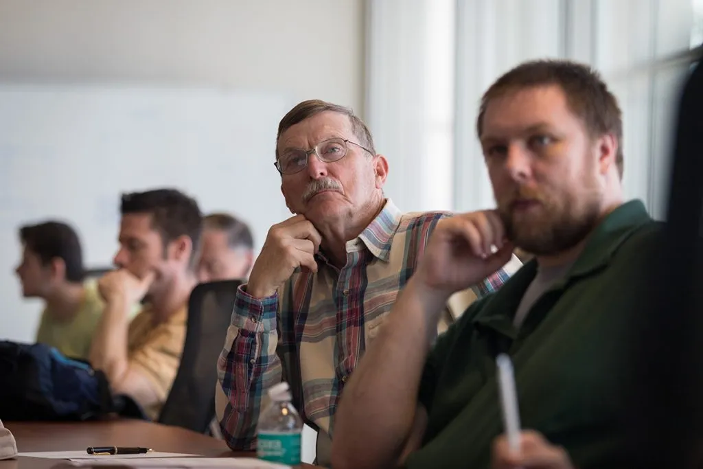 Men listening to Dr. Soifer's presentation.